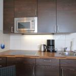 Kitchen with dark cabinets, microwave, coffee machine, and sink.