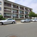 Villa with balconies and parked cars in front