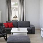 A living room with a gray sofa, red cushions, and a white coffee table.