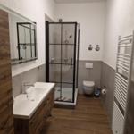 Bad mit Dusche, Waschbecken und Heizkörper
