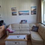 Living room with corner sofa, coffee table, and kitchen area against the wall.