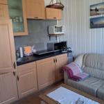 Kitchen with wooden cabinets and sofa in living area