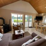 Living and dining area with wooden ceiling, fireplace, and view of water.