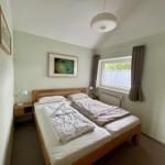 Bedroom with double bed, window, and two nightstands.