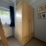 Bedroom with wardrobe, window, and wall pictures