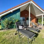 Green house with terrace and sun loungers in the garden