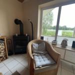 Room with armchair, wood stove, and view of water