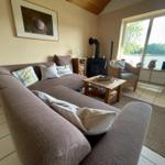 Living room with sofa, fireplace, and view of the lake.