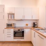 Kitchen with white cabinets, wooden countertop, and built-in stove.