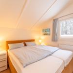 Bedroom with double bed, nightstand, window, and warm lighting.
