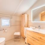 Bathroom with sink, mirror, toilet, and window