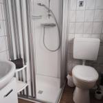 Bathroom with shower, toilet, and sink.