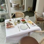 Tisch mit Frühstückszubehör und Wickerstühlen auf Terrasse.