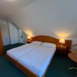 Schlafzimmer mit Doppelbett, Nachttischen und Schrank unter schräger Decke.
