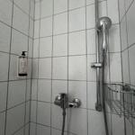 Dusche mit Duschbrause, Handbrause und Seifenspender an Wand