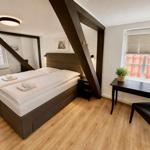 Schlafzimmer mit Doppelbett, Schreibtisch und Fenster mit Blick auf Dach