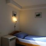 Ein Schlafzimmer mit einem Bett, einem Nachttisch und einer Wandlampe.
