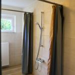 Dusche mit Duschbrause, Fenster und Heizkörper