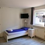 Ein Schlafzimmer mit einem Bett, einem Nachttisch, einem Fernseher und einem Fenster.
