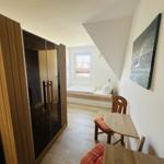 Zimmer mit Dachschrägen, Bett, Tisch, Stuhl und Sauna
