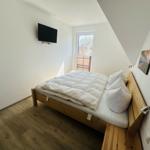 Schlafzimmer mit Bett, Fenster und Wand-TV
