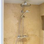 Dusche mit Duschbrause und Handbrause an der Wand