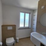 Badezimmer mit Toilette, Waschbecken und Fenster
