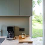 Küche mit Spüle, Kaffeemaschine und Blick auf den Garten