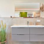 Badezimmer mit Waschbecken, Spiegel und Pflanzen