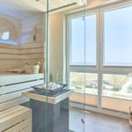 Sauna mit Holzwand und Blick auf den Strand