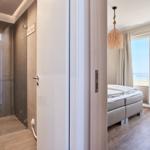 Schlafzimmer mit Blick aufs Meer und angrenzende Dusche.