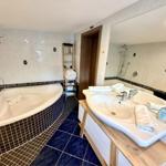 Badezimmer mit Badewanne, Dusche und Waschbecken mit Spiegel.