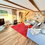 Wohnzimmer mit Sofa, Kamin und rotem Teppich