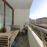 Balcony with bench, table, and view of buildings