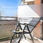 Terrasse mit Liegestuhl, Sonnenschutz und Blick auf Bäume.