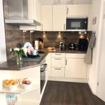Kitchen with white cabinets, dark wood flooring, and stainless steel stove.