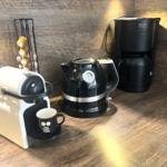 Coffee machine, kettle, and coffee maker on wooden surface.