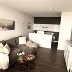 Living area with sofa, coffee table, and TV. Background: sleeping area with bed.