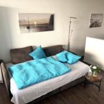 Bedroom with bed, wall art, and small table with flowers.