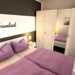 Bedroom with bed, wardrobe, and wall decoration.