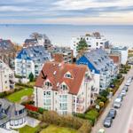 Haus mit rotem Dach und Balkon an Strandpromenade