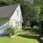 Wohnhaus mit Gartenterrasse und Blumenbeet im Grünen.