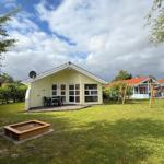 House with garden, terrace, and playground. Wooden frame around sandbox.