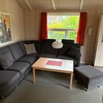 Living room with gray sofa, wooden table, and white cabinet.