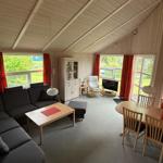 Living and dining area with sofa, dining table, and large windows.