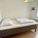 A bedroom with a bed, a window, and a heater.