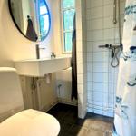 Bathroom with toilet, sink, and shower with shower curtain.