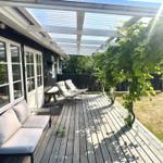 Deck with seating under roof and climbing plant