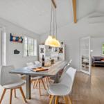 Dining room with table, chairs, and view to garden. Passage to living kitchen.