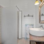 Bathroom with sink, mirror, and shower.